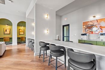 A white counter with a green cabinet and a painting on the wall.